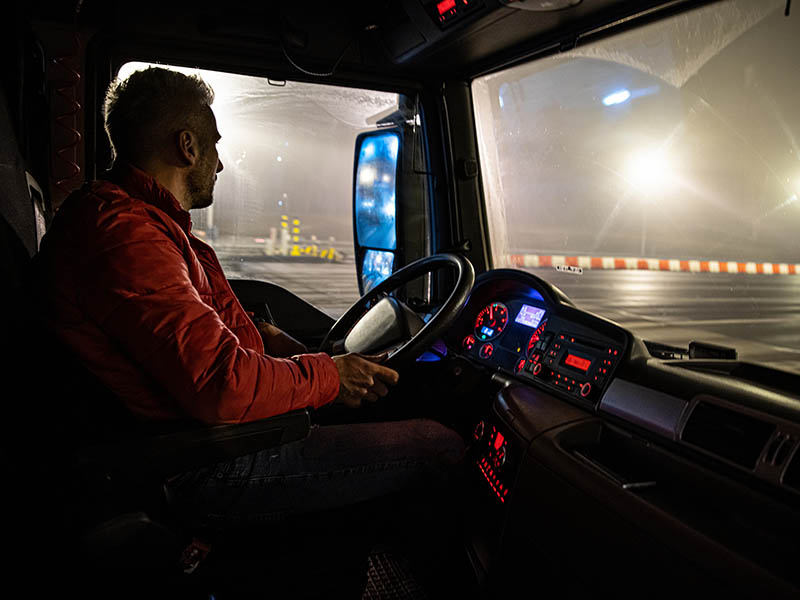 Truck driver on route at night.