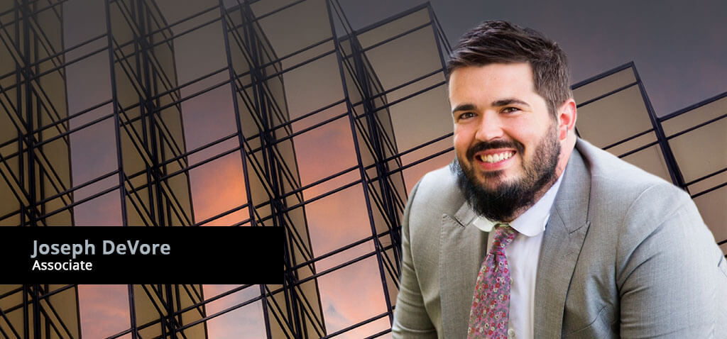 Associate Attorney, Joseph DeVore, against modern architecture.