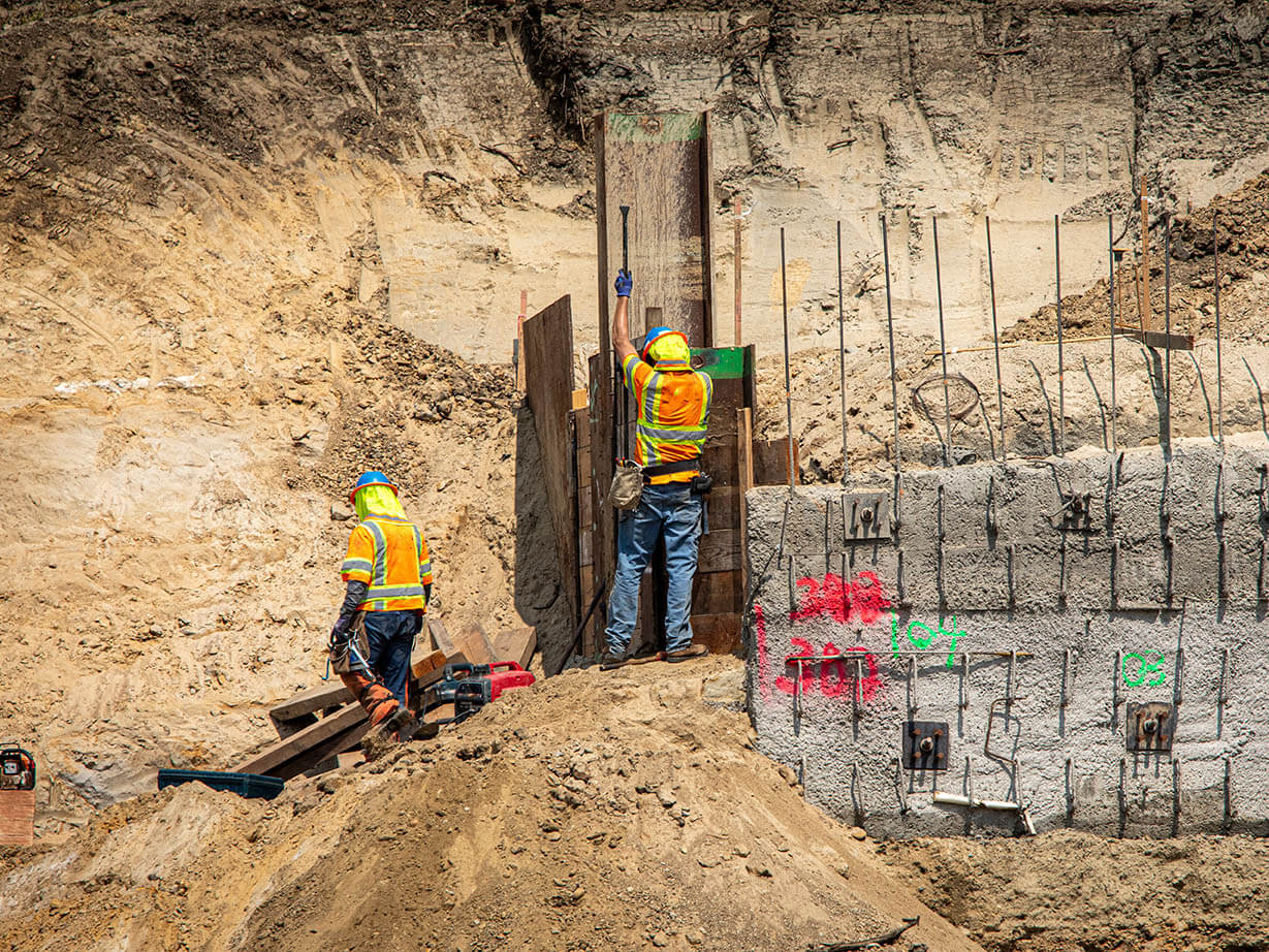 Workers on a construction site building out a foundation.